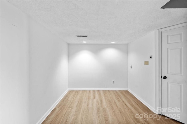 empty room featuring light hardwood / wood-style floors and a textured ceiling