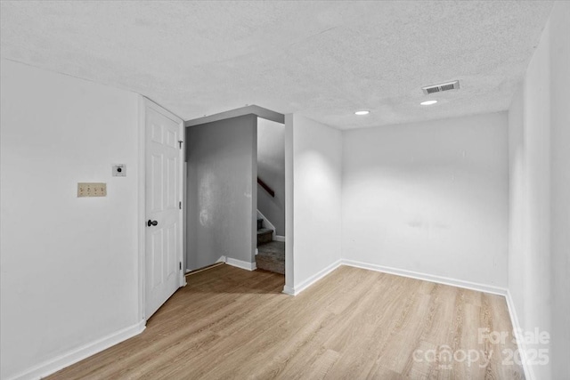 empty room featuring a textured ceiling and light wood-type flooring