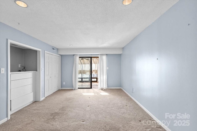 carpeted empty room with a textured ceiling