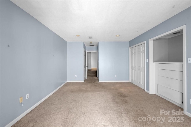 unfurnished bedroom with light colored carpet and a textured ceiling