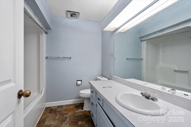 bathroom featuring vanity, toilet, and a textured ceiling
