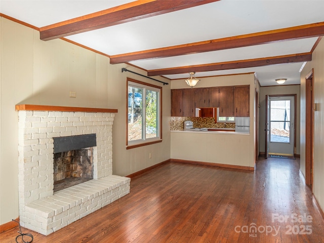 unfurnished living room with beam ceiling, plenty of natural light, and dark hardwood / wood-style floors