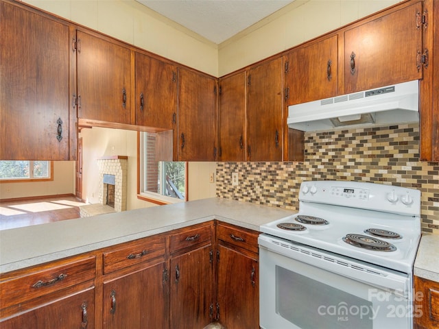 kitchen with backsplash, a fireplace, and white range with electric stovetop