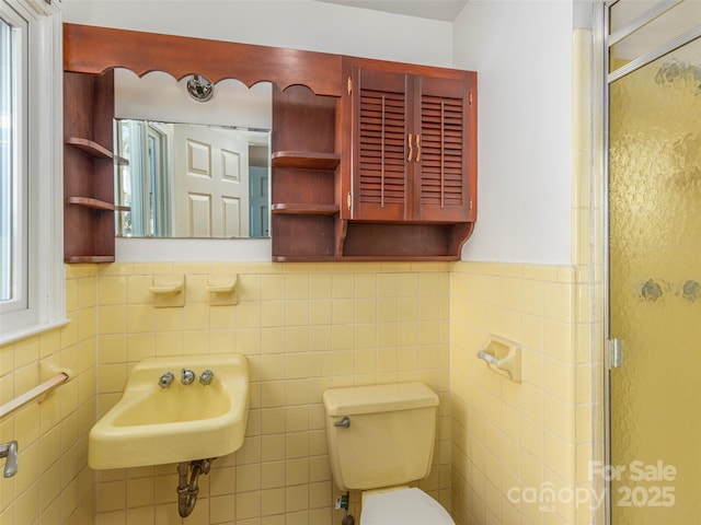 bathroom with walk in shower, sink, tile walls, and toilet