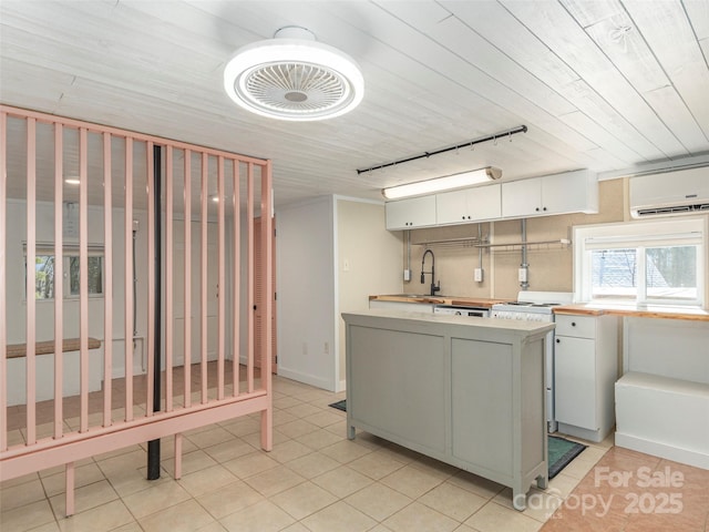 washroom featuring a wall mounted air conditioner, wooden ceiling, sink, and light tile patterned flooring