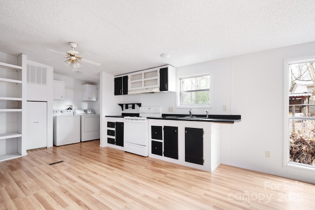 kitchen featuring sink, light hardwood / wood-style flooring, white range with electric stovetop, washer and dryer, and a textured ceiling