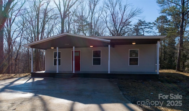 view of front of home with a porch and a carport