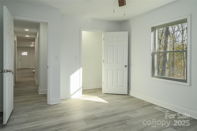 unfurnished bedroom with ceiling fan and light hardwood / wood-style floors