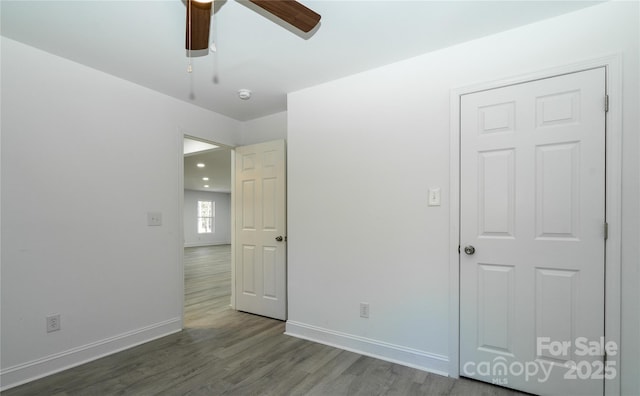 unfurnished bedroom featuring ceiling fan and dark hardwood / wood-style floors