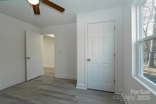 unfurnished bedroom featuring multiple windows, light hardwood / wood-style flooring, and ceiling fan