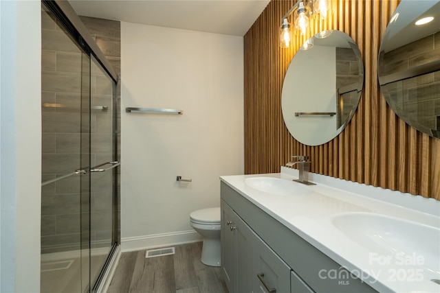 bathroom featuring a shower with shower door, wood-type flooring, toilet, and vanity