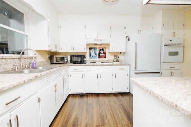 kitchen with white appliances and white cabinetry