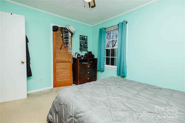 carpeted bedroom featuring baseboards, ornamental molding, and a ceiling fan