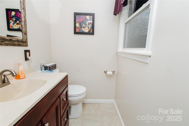 half bath with baseboards, vanity, toilet, and tile patterned floors