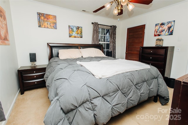 bedroom with ceiling fan, light colored carpet, visible vents, baseboards, and a closet