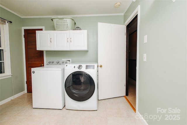 laundry room featuring crown molding, baseboards, cabinet space, and washer and dryer