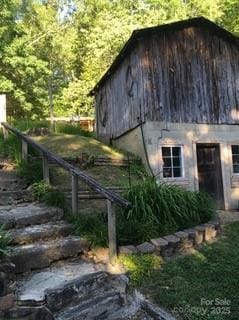 view of side of property featuring an outdoor structure and a barn