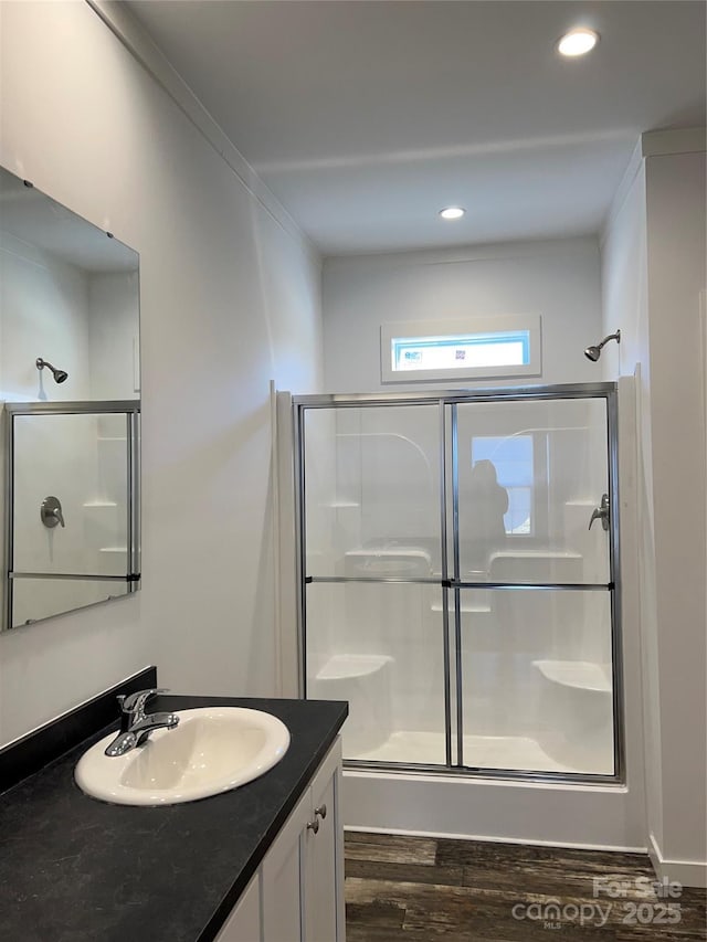 full bathroom featuring a shower stall, ornamental molding, wood finished floors, and vanity