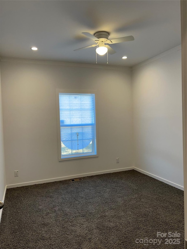 empty room with recessed lighting, dark carpet, ornamental molding, ceiling fan, and baseboards