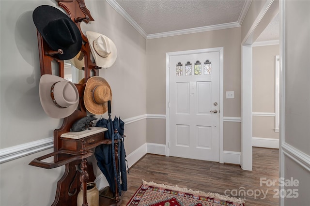 entryway with wood-type flooring, a textured ceiling, and ornamental molding