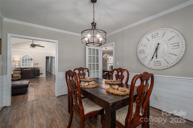 dining room with ceiling fan with notable chandelier, dark hardwood / wood-style flooring, a textured ceiling, and ornamental molding