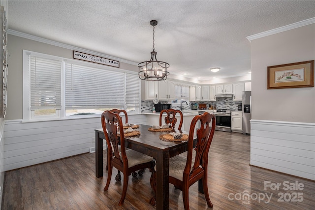 dining area featuring sink, dark hardwood / wood-style floors, and crown molding