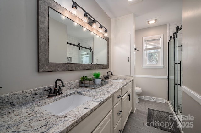 bathroom with toilet, vanity, and walk in shower