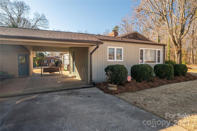 view of side of home with a carport