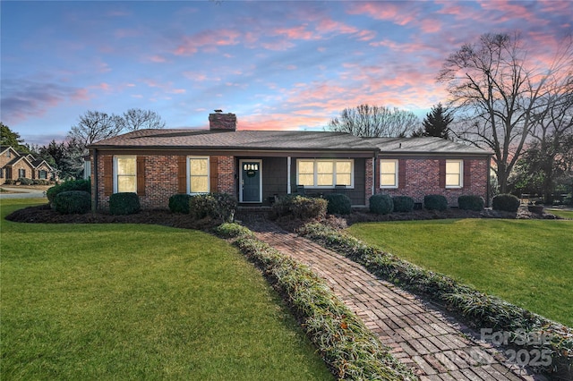 single story home featuring a front lawn, brick siding, and a chimney