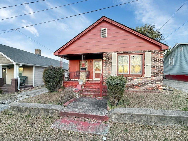 bungalow-style house with covered porch and brick siding