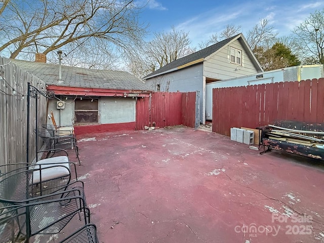 view of patio featuring an outbuilding and fence