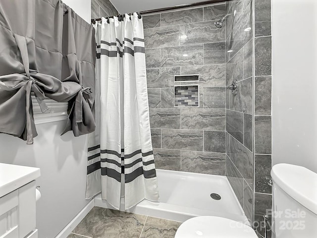 full bath featuring a stall shower, vanity, and toilet