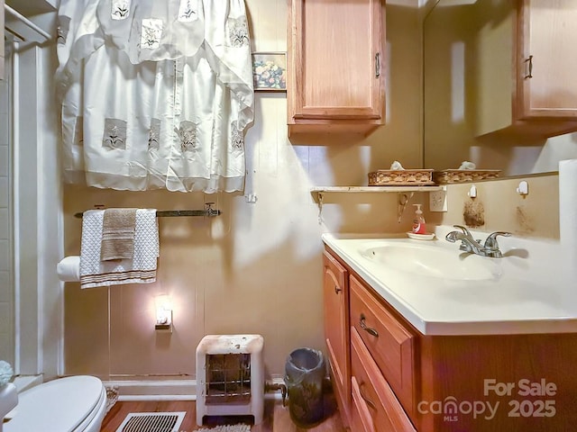 bathroom with toilet, visible vents, and vanity