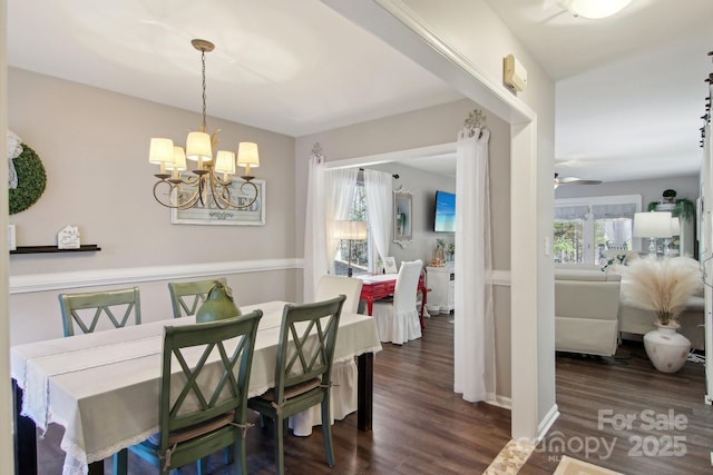 dining space with ceiling fan with notable chandelier and dark hardwood / wood-style floors