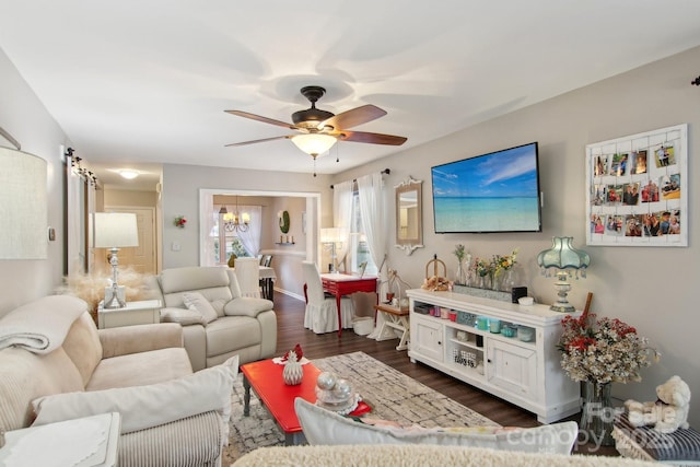 living room with dark wood-type flooring and ceiling fan with notable chandelier