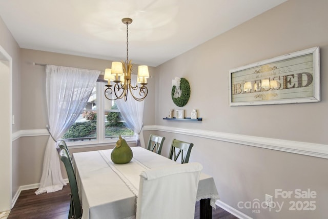 dining area with dark hardwood / wood-style flooring and a notable chandelier