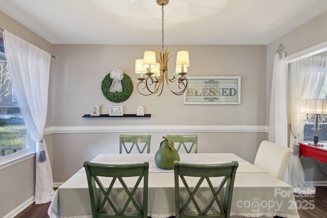 dining room featuring dark wood-type flooring and a chandelier