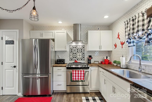 kitchen featuring white cabinetry, appliances with stainless steel finishes, sink, and wall chimney exhaust hood