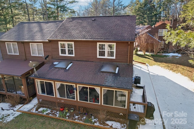 rear view of property featuring cooling unit and a sunroom