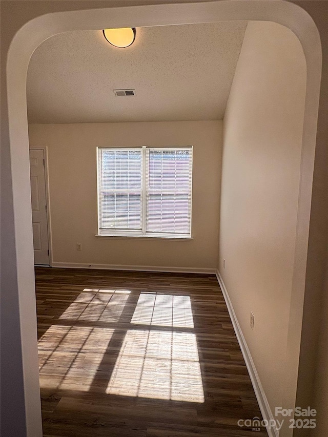 spare room with dark wood-type flooring