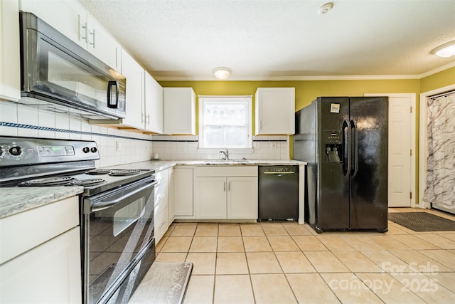 kitchen with light tile patterned floors, sink, white cabinetry, black appliances, and decorative backsplash