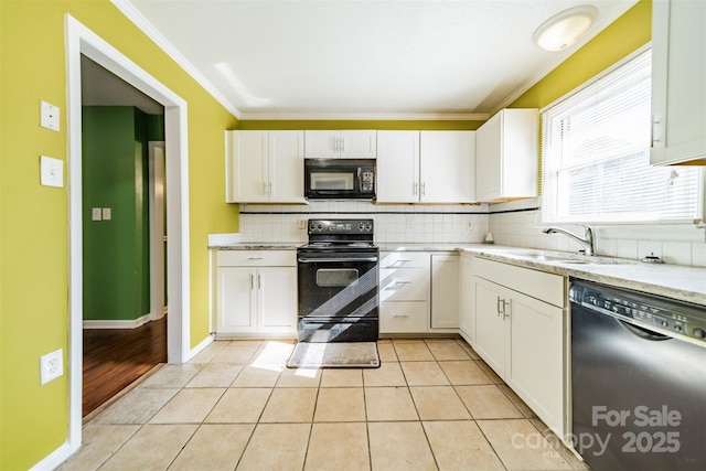 kitchen with white cabinetry, sink, light tile patterned floors, black appliances, and a healthy amount of sunlight