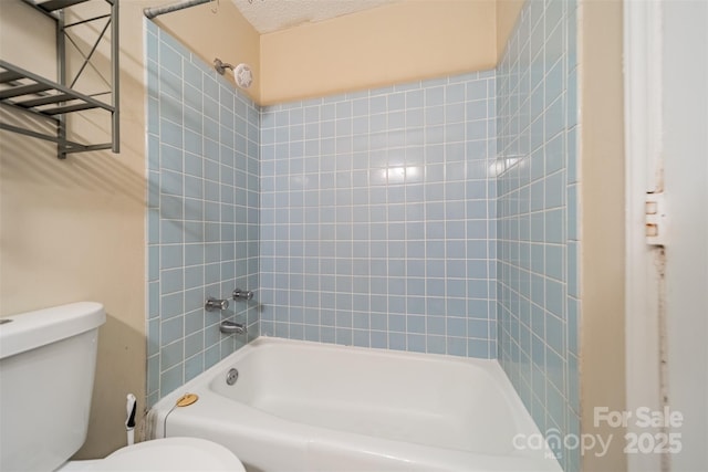 bathroom featuring a textured ceiling, toilet, and shower / bath combination