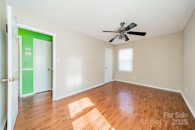 empty room with hardwood / wood-style flooring and ceiling fan