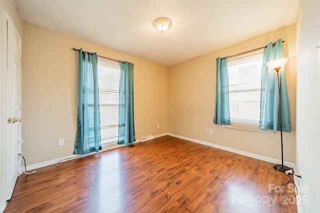 spare room with hardwood / wood-style flooring and a textured ceiling