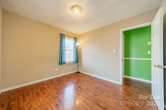 spare room with wood-type flooring and a textured ceiling