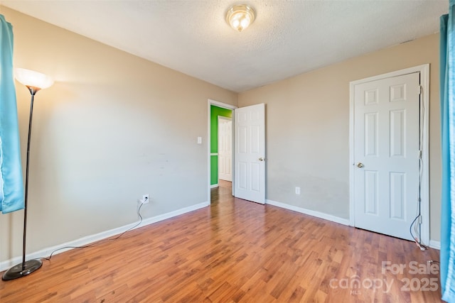 unfurnished bedroom featuring hardwood / wood-style floors and a textured ceiling