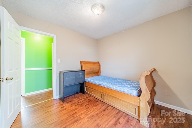 bedroom featuring hardwood / wood-style flooring and a textured ceiling