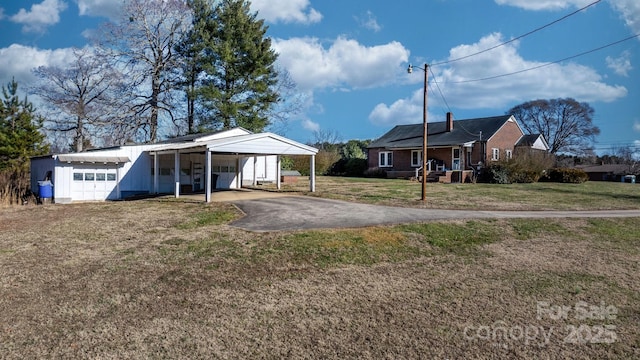 view of front of property with a front yard, a carport, a porch, and a garage