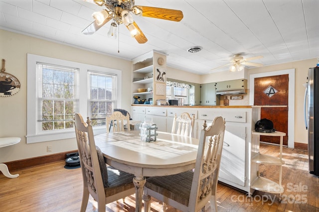 dining room with light hardwood / wood-style floors and ceiling fan